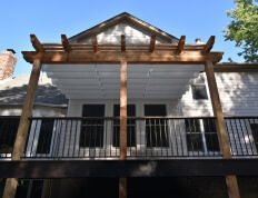 wooden and composite pergola on white house